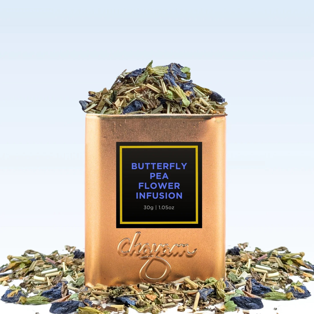 Copper container of butterfly pea flower infusion with dried flowers on a light blue background