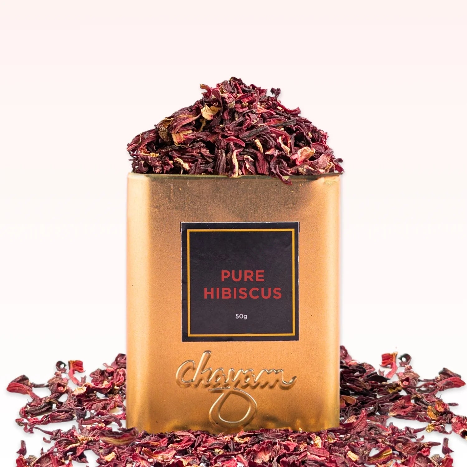 Gold container of 'Pure Hibiscus' with dried hibiscus flowers on a white background